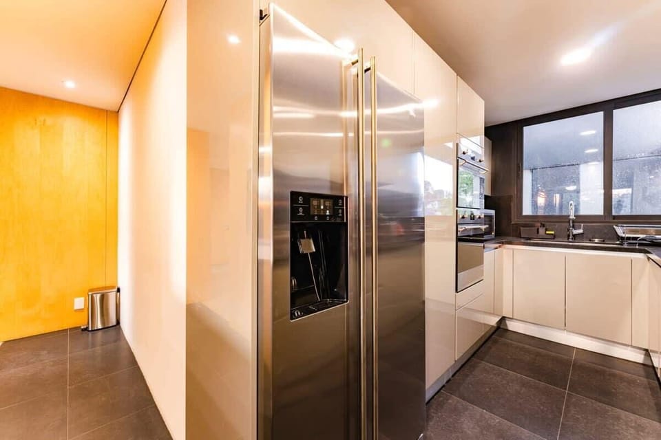 Sleek double-door fridge/freezer and built-in ovens.