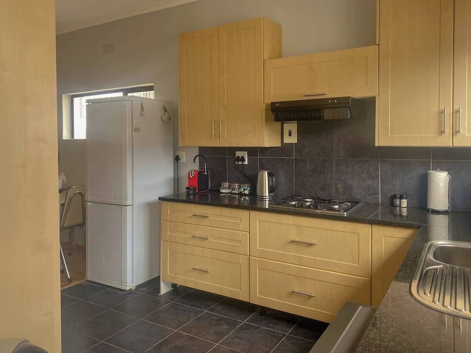 Kitchen with a coffee pod machine, fridge and breakfast nook.