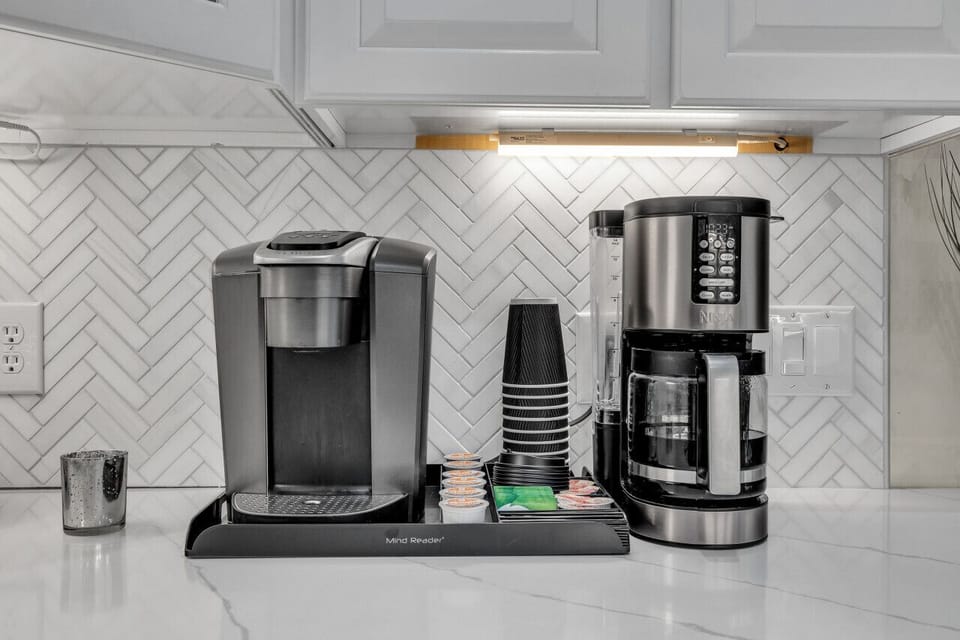Coffee area equipped with Keurig, 14 cup coffee pot, K-cups, sweeteners, and creamers
