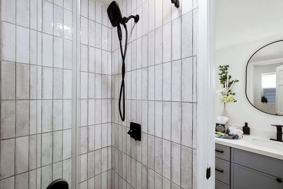 Full bathroom with glass shower provides convenient access for guests staying in the home's additional bedrooms.