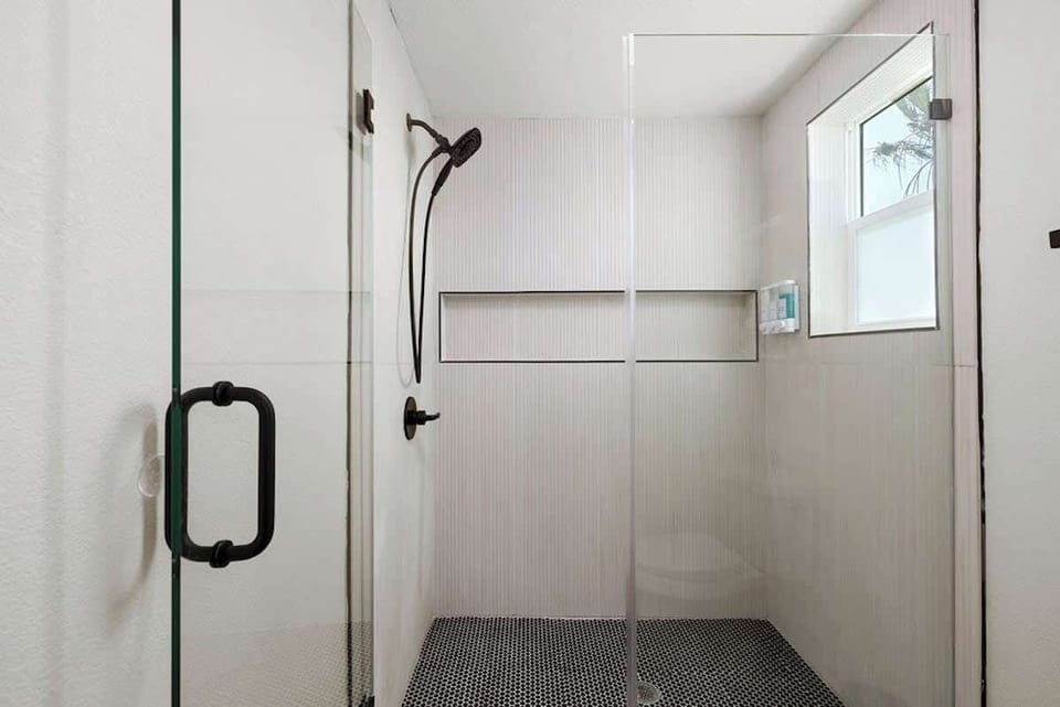 Recently renovated primary ensuite with a spacious walk-in shower. Shampoo, conditioner, body wash, and other essential bath amenities are provided for every stay.