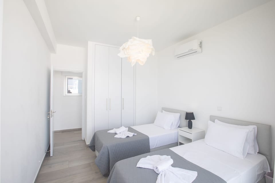 Bedroom 2 with two single beds and shared balcony