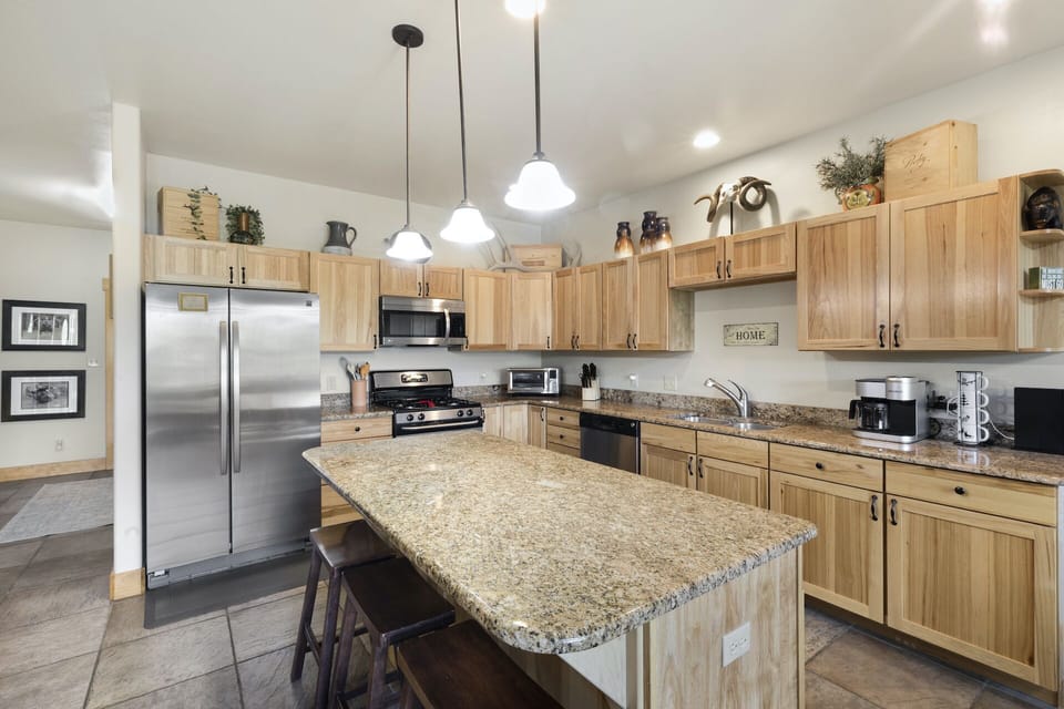 Fully equipped kitchen with granite countertops and stainless-steel appliances.