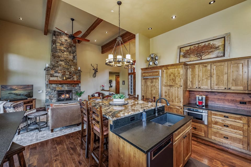 Luxury meets functionality in this mountain home's main dining area, featuring granite countertops and a spacious center island that serves as the perfect gathering spot for family and friends