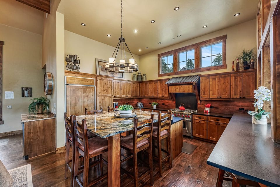 Luxury meets functionality in this mountain home's main dining area, featuring granite countertops and a spacious center island that serves as the perfect gathering spot for family and friends