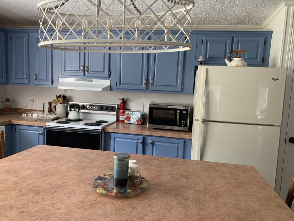 Kitchen with electric stove, new toaster, microwave with air fryer