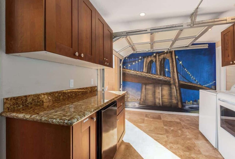 Laundry Room decorated with eye-catching mural, featuring washer and dryer, and additional storage space.