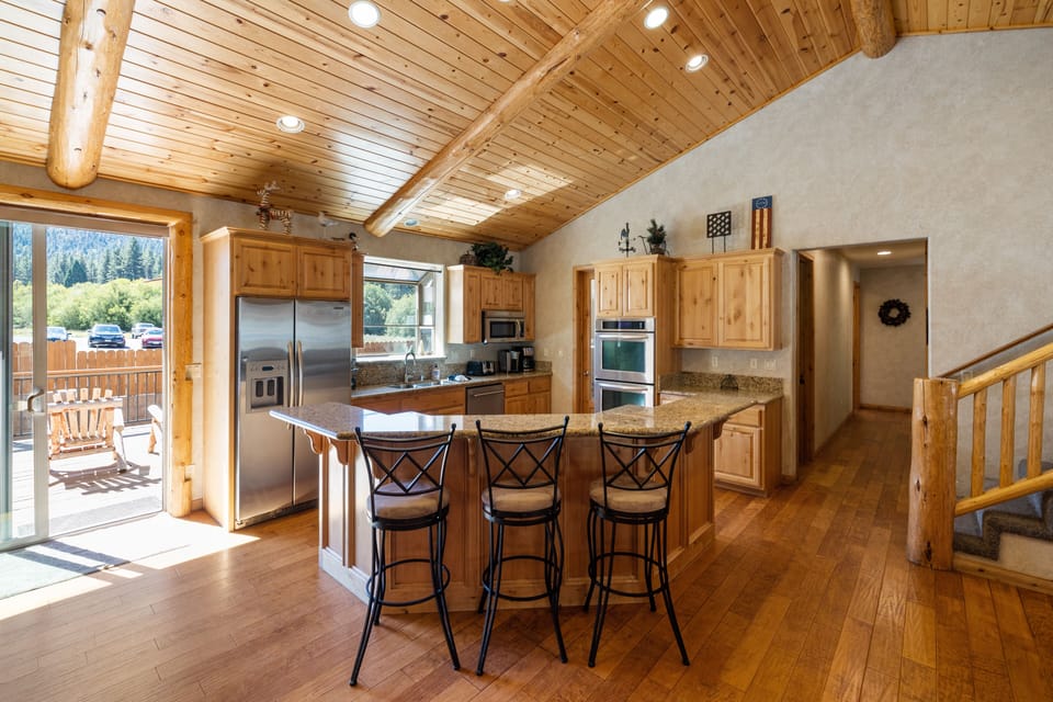 Fully equipped kitchen with barstool seating at the island counter.