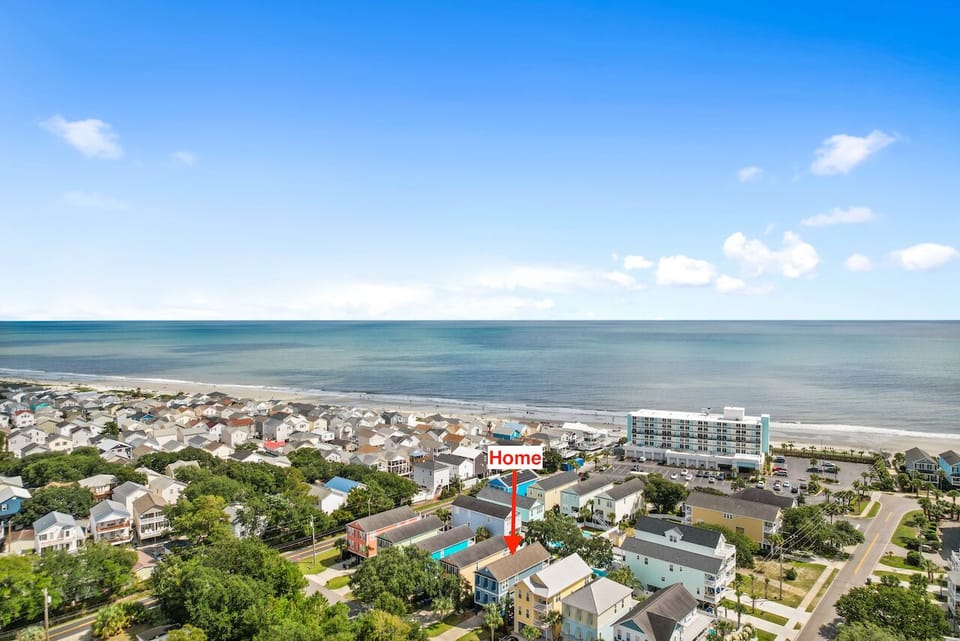 Aerial view showcasing the property's prime location within a charming coastal neighborhood, just steps from pristine sandy shores.