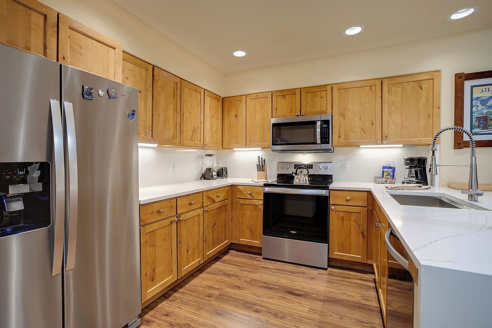 Your fully equipped kitchen features warm wood cabinets, stainless steel appliances, and ample counter space for preparing memorable meals together.