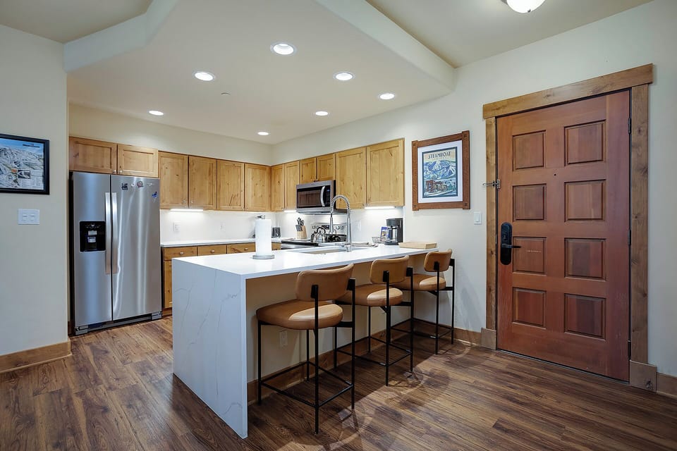 Your fully equipped kitchen features modern appliances, ample counter space, and a breakfast bar perfect for morning coffee or casual meals.
