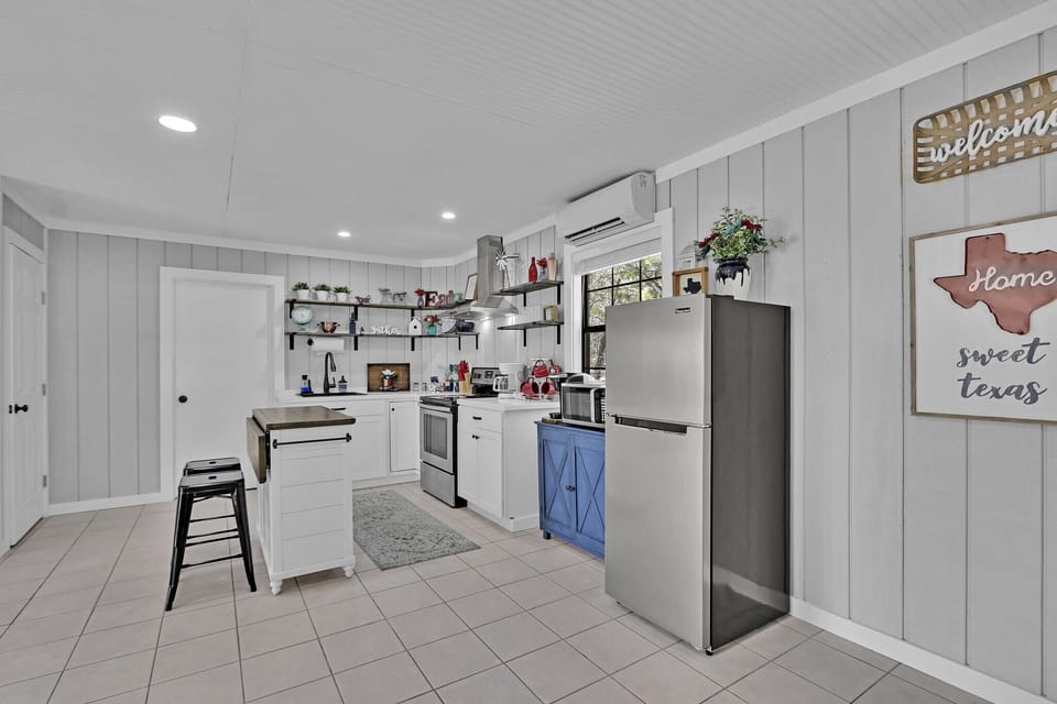 The kitchen is fully stocked with stainless steel appliances