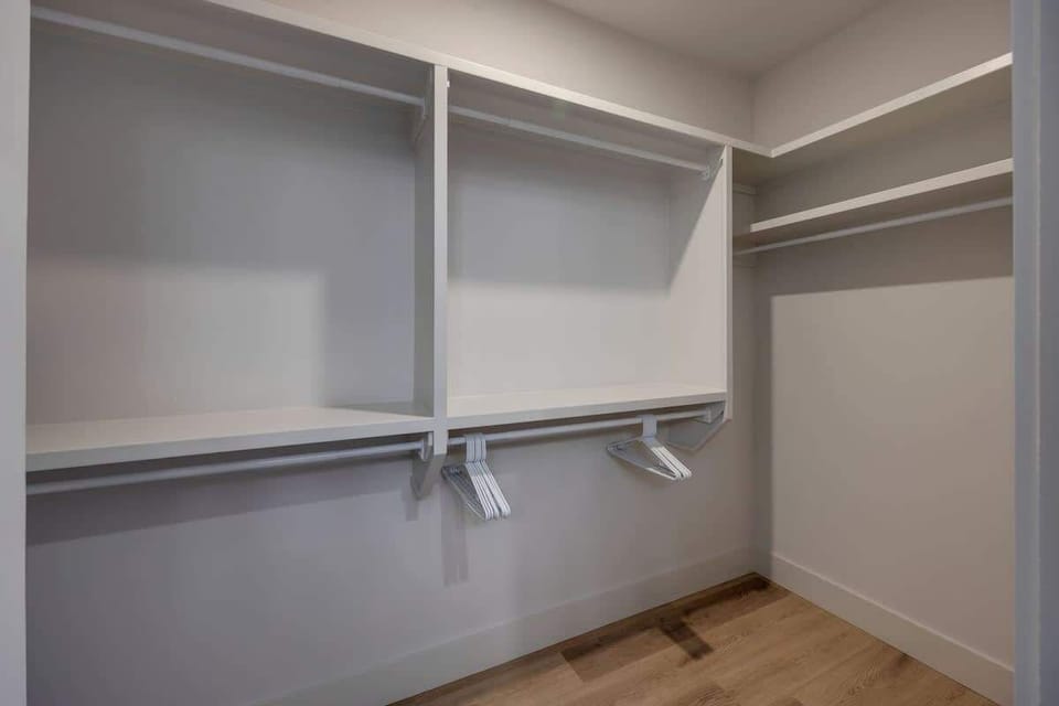 Primary Bathroom (Primary Bedroom en-suite) with dual vanity sinks, large walk-in closet, and stand-in shower.