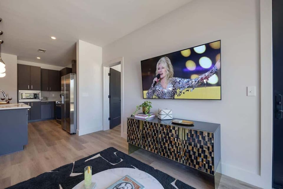 Bright open concept living area with floor to ceiling windows providing panoramic views of Midtown! Features designer furniture and smart TV!