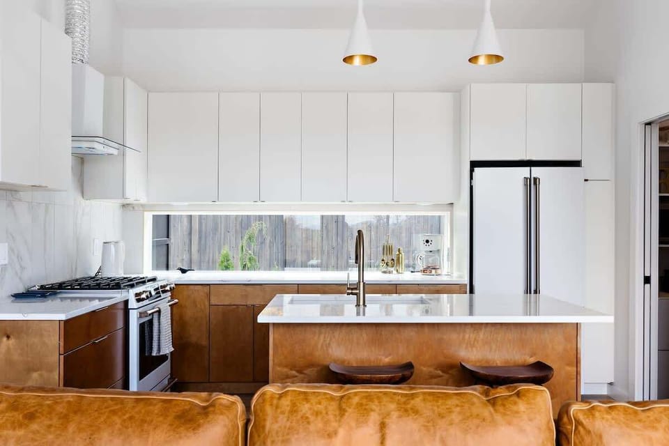 Minimalist design, maximum impact. This streamlined kitchen features custom cabinetry, top-tier appliances, and a living backsplash that brings nature indoors. Cook, sip, and connect around the central island.