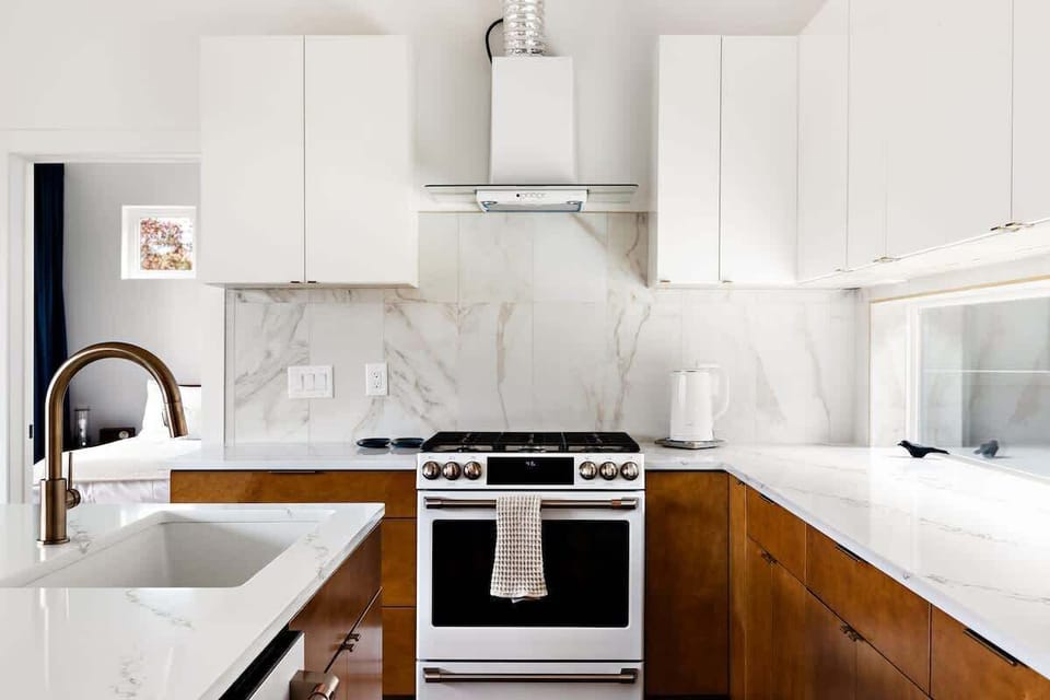 Minimalist and magazine-worthy. Enjoy custom cabinetry, a full suite of appliances, and marble-inspired surfaces that elevate your stay. The flow between kitchen, dining, and living makes it perfect for cooking and connection.
