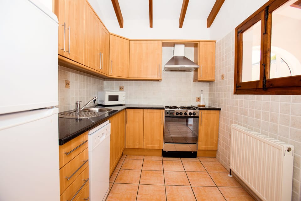 Kitchen is fully equipped with coffee maker, toaster, kettle, oven, pans, dishes