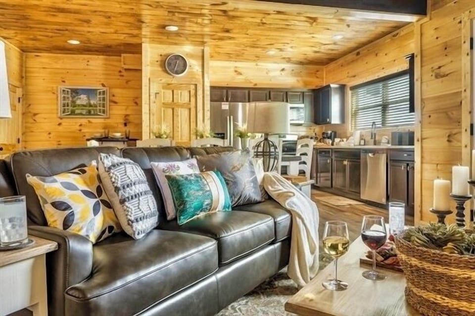 A luxurious living space featuring a spacious, comfortable couch, armchairs, and a 65-inch LED smart TV, surrounded by elegant decor.