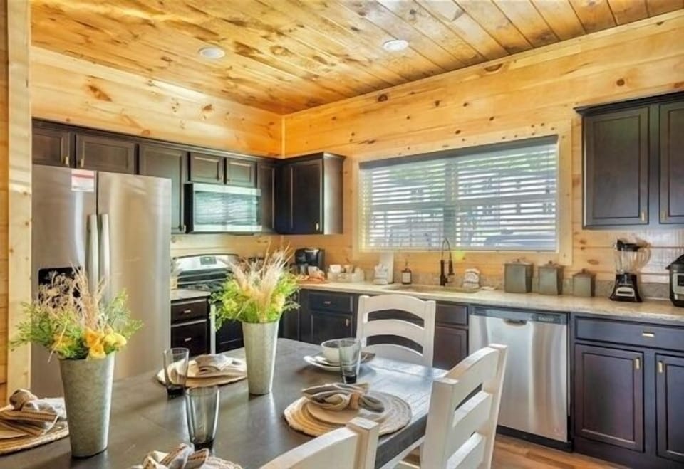 A chef's dream kitchen with top-of-the-line appliances, a generous dining table, and tasteful artwork.