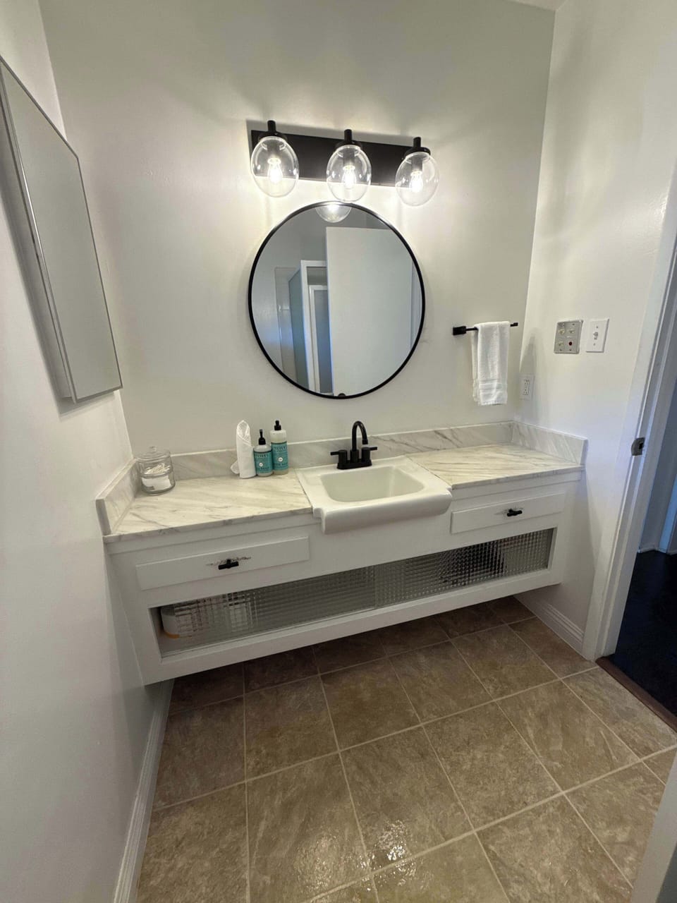Experience modern elegance in this bright, spa-like bathroom featuring sleek marble-style countertops, chic matte black fixtures, and a clean, serene atmosphere perfect for refreshing your senses.
