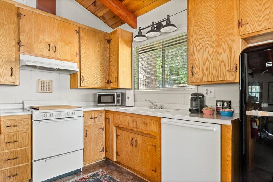 The kitchen is well-appointed with modern appliances, including a refrigerator, stove, microwave, drip coffee machine, and dishwasher.