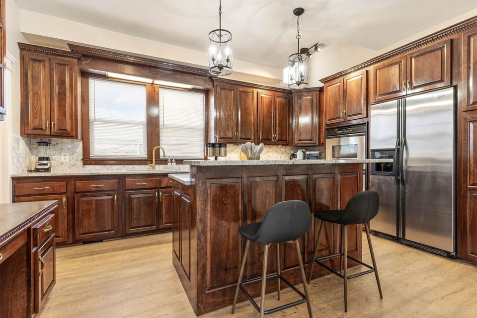 Gourmet Kitchen: Elegant wooden cabinetry and stylish island for your culinary adventures! Stocked with all the culinary essentials.