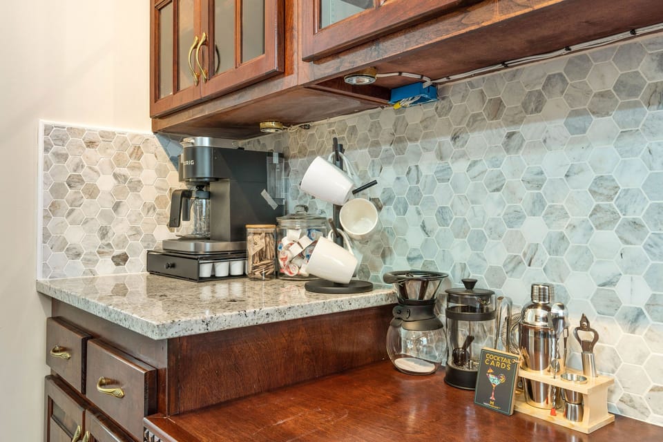 Enhanced coffee bar including coffee maker, K-cups, coffee grounds, French press, pour over, sugar and creamer