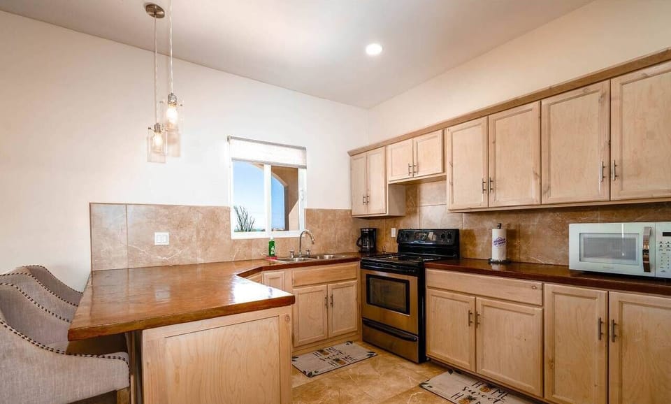 This full kitchen at Casa Desert Rose in El Dorado Ranch San Felipe BC MX includes a stove, refrigerator, microwave, and counter space — everything you need to prepare meals for your group.