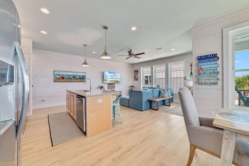 The dining, kitchen, and living areas seamlessly blend together, creating a spacious and inviting environment where cooking, dining, and relaxation coexist.