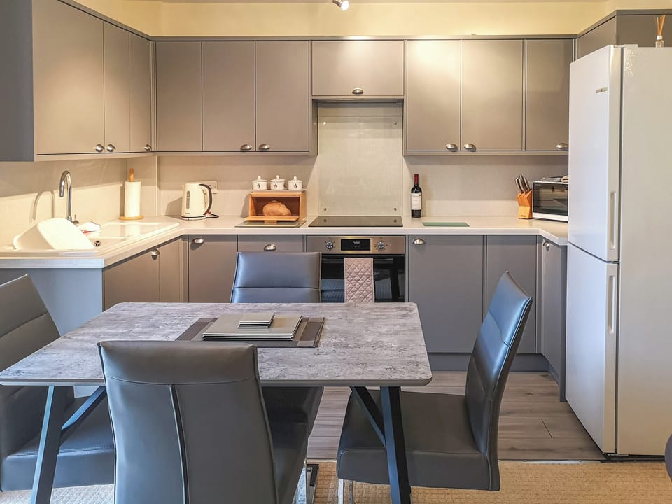 Kitchen/diner with bottle of wine and homemade bread | Cysgod Y Coed, Llanbedr