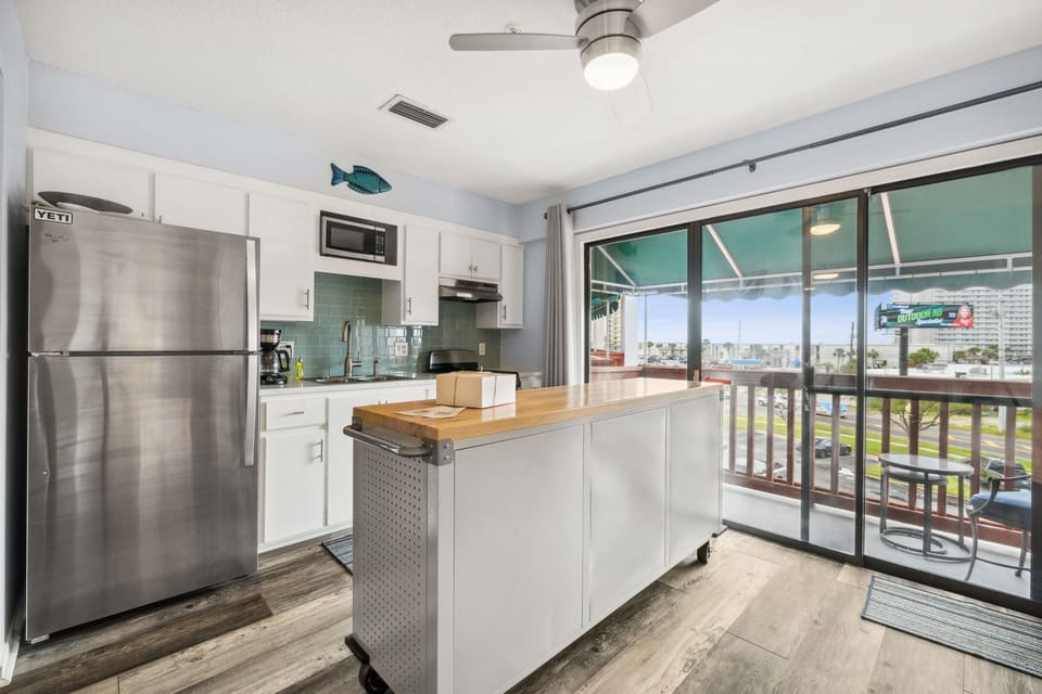 Kitchen with balcony views of the junction at Joan Avenue and Thomas Drive! 