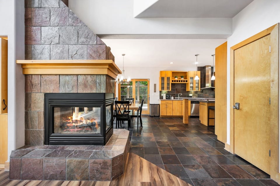The fireplace unites the living room space and the open concept kitchen/dining area.