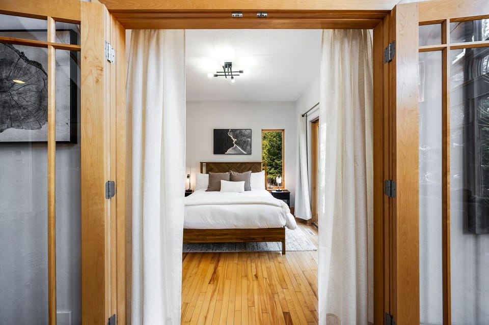 The first floor bedroom features a plush and luxurious queen sized bed with a walkout directly to the deck.