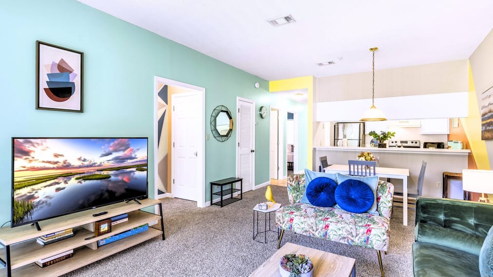 A cozy living area with a smart TV and bright pillows.