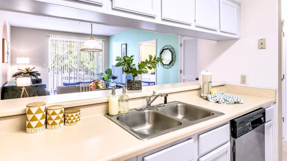 A bright kitchen with a double sink and bar seating.