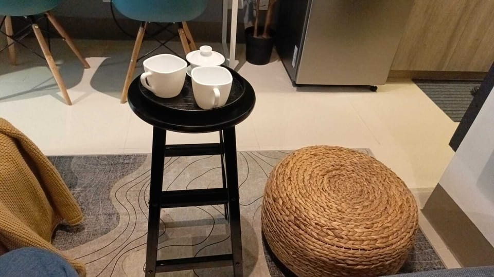 Living room Area with Stool with Serving Tray and setting.