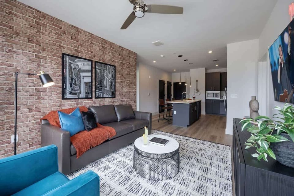 Inviting designer furnished living space featuring a comfortable sleeper sofa, a Smart TV for entertainment and a private covered balcony.