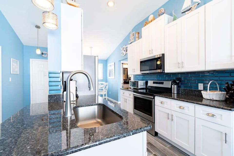 Modern kitchen with granite countertops and blue tile backsplash
