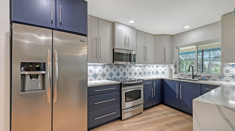 Kitchen with light grey cabinetry, professional range, and microwave