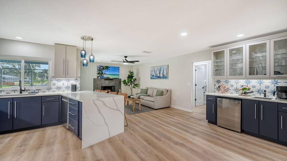 Modern kitchen with dark navy cabinetry, large center island, and open plan layout