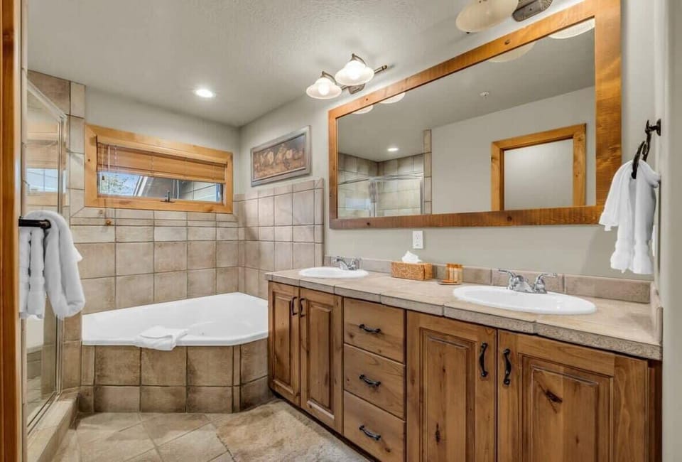 The master bathroom is a spa-like space with a spacious soaker bathtub, double-sink vanity, and a walk-in glass shower.