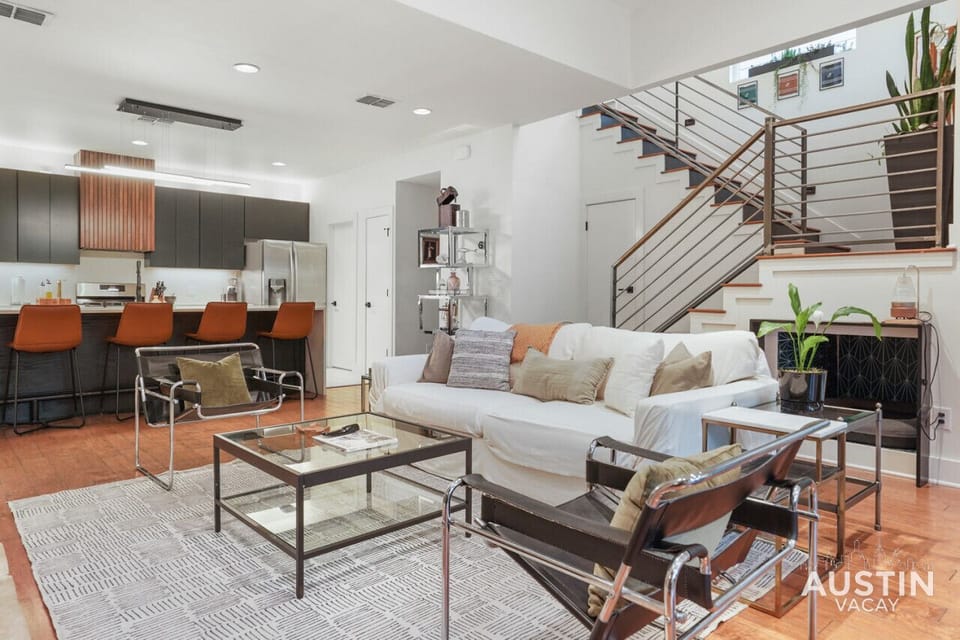 Large open living room with sofa, smart tv, conversational seating, dining and kitchen with island