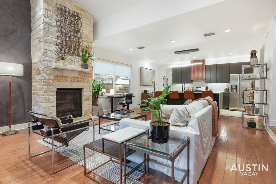 Large open living room with sofa, smart tv, conversational seating, dining and kitchen with island