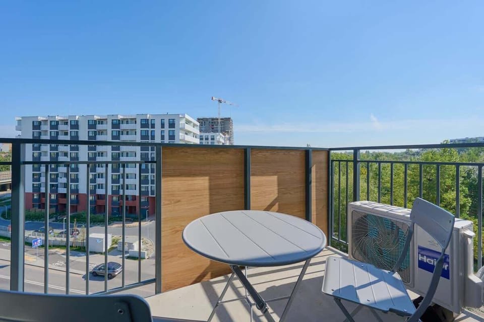 Spacious balcony with outdoor furniture. 