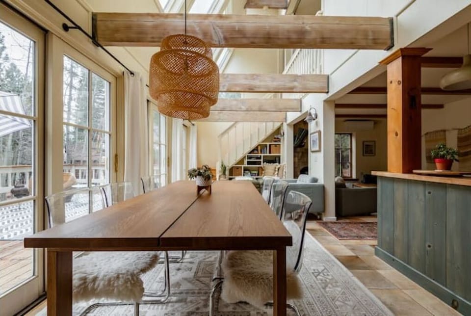 The dining table seats up to 8 people, with stools at the end of the table.