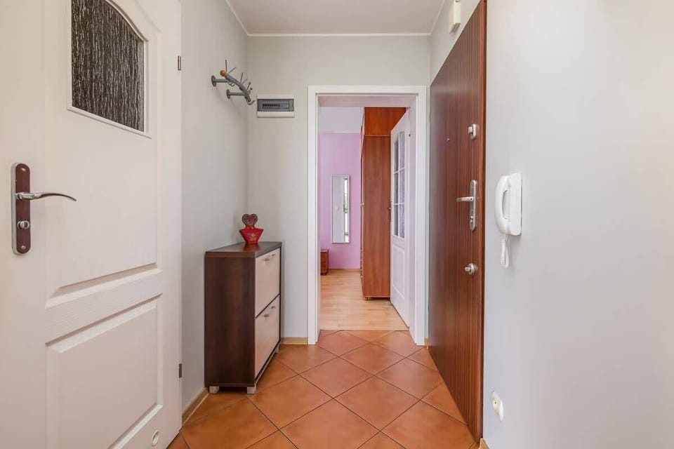 A hallway with tiled flooring and minimalistic decor, connecting the living and private spaces.
