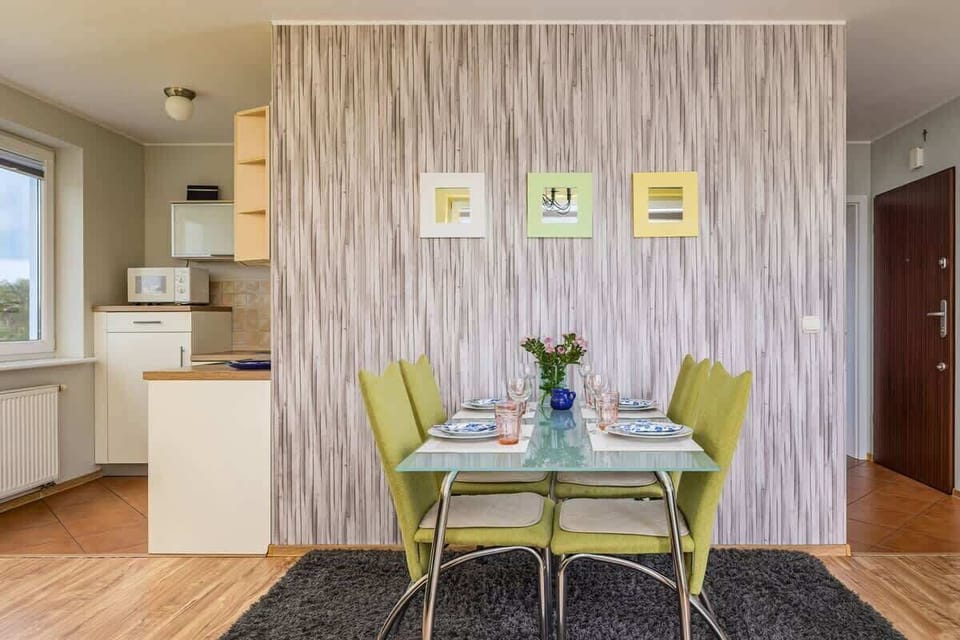 A compact but functional kitchen with wooden cabinetry, a window, and tiled backsplash for practicality.
