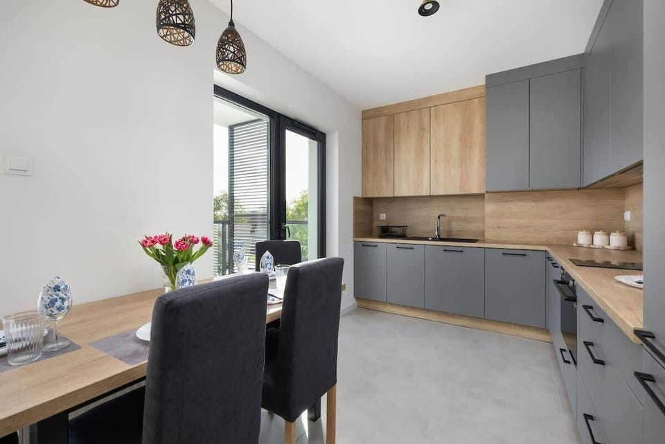 A view of the kitchen and dining area, showcasing the seamless integration of spaces with bright, modern finishes.
