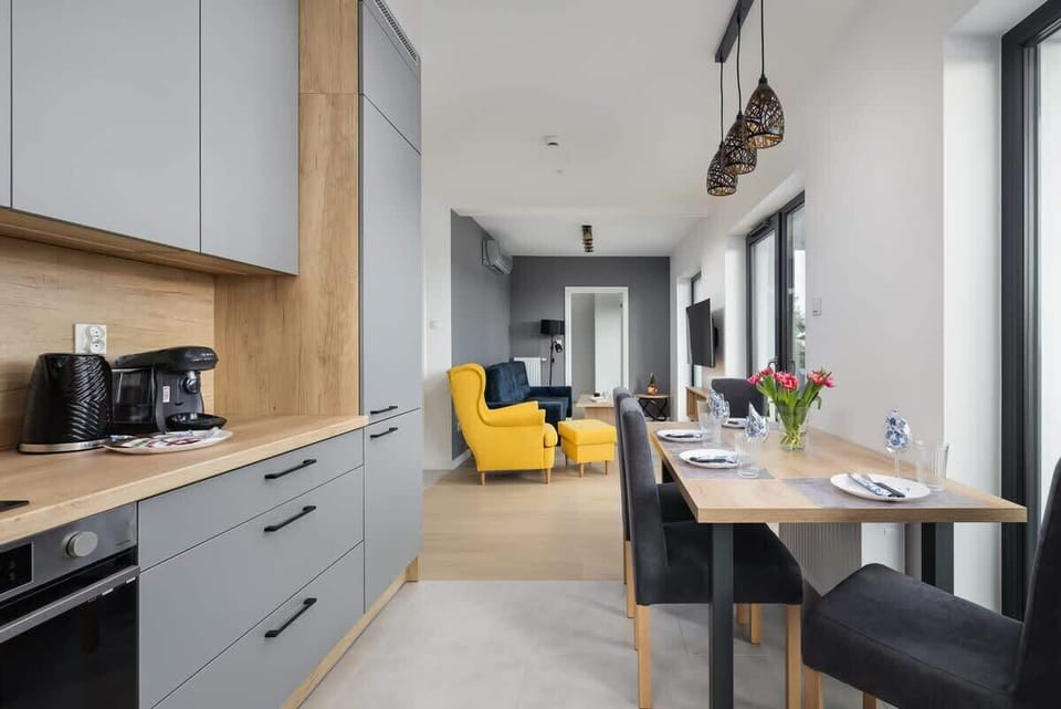 A compact and functional kitchen featuring modern cabinetry, a coffee maker, and bright lighting.
