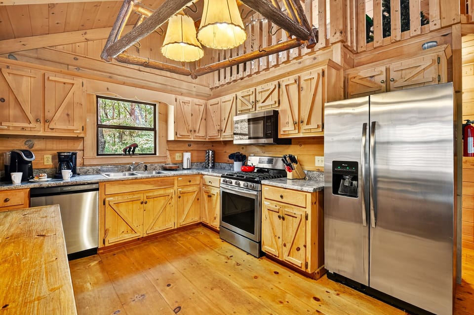 The beautiful kitchen features stainless steel appliances, spacious counter areas, and all the essentials for home-cooked meals